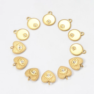 Detailed view of 18k gold plated evil eye and heart charms with zircon inlay