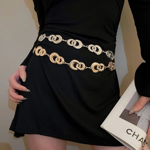 Close-up of interlocking geometric gold and silver waist chains with rhinestone inlay