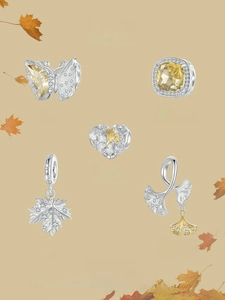 Macro detail of S925 sterling silver autumn leaf charms with gold enamel and zircon stones