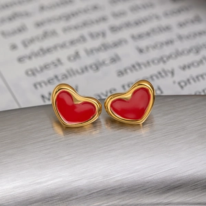 Vue macro de boucles d'oreilles cœur rouge minimalistes avec bordure dorée élégante