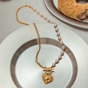 Detail of 18K gold heart pendant and toggle clasp on a half-pearl necklace link