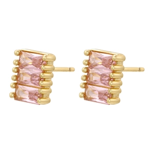 Macro shot of rectangular tiered gold earrings with pink gemstones and studded edges