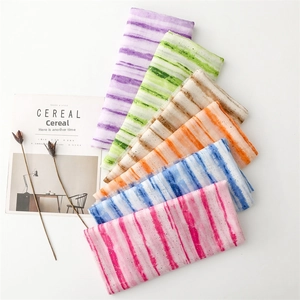 Detailed view of rolled scarves featuring gold foil bamboo patterns in gradient colors
