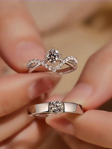 Close-up of silver-tone zircon engagement rings with crown and heart-shaped detailing
