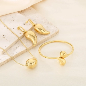 Three-piece gold jewelry set featuring sleek waterdrop necklace, earrings, and bracelet