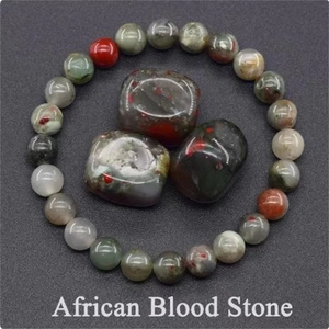 Macro detail of African Blood Stone beaded bracelet and polished raw gemstones