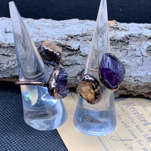 Detail of vintage adjustable rings with raw amethyst and citrine stones on bronze band