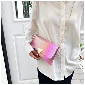 Detail of pink holographic wallet with metal heart clasp and golden chain strap