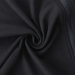 Gros plan sur la texture en maille côtelée noire avec fermeture éclair sur la robe