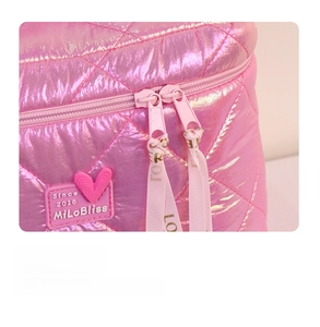 Detail of pink quilted cosmetic bag featuring double zippers and a heart logo tag