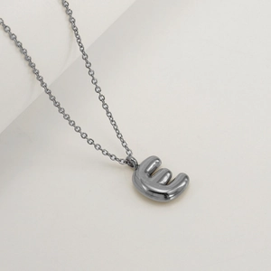 Detail of 3D bubble letter E pendant with polished gunmetal finish on a delicate chain