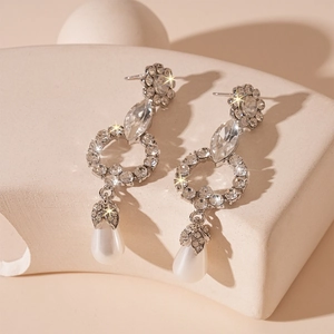 Macro shot of sparkling floral drop earrings with rhinestones and waterdrop imitation pearls