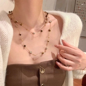 Détail du collier multicouche plaqué or 18 carats avec œil de tigre et perles sur tricot