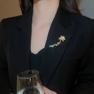 Detailed view of an elegant flower brooch with pearls and zircons on a black blazer lapel