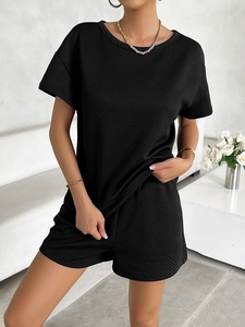 Close-up of black two-piece knit set featuring unique diamond texture and crew neck design