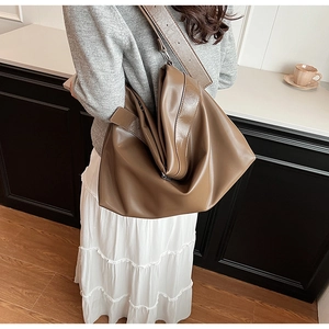 Gros plan du cabas en cuir PU marron montrant la texture souple et les détails pliés