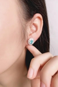 Primo piano di orecchini con pietra Paraiba blu ovale e contorno di diamanti scintillanti