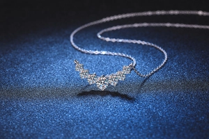 Close-up of S925 silver necklace featuring brilliant-cut moissanite stones on a curved pendant