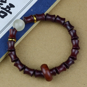 Détail du bracelet en bois en forme de bambou avec perle blanche et intercalaires dorés