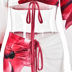 Detail of white two-piece skirt set featuring red floral print and ruched drawstring design