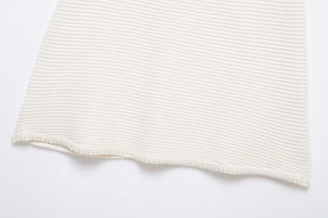 Vue détaillée du tissu en maille blanche avec garniture en perles et texture délicate
