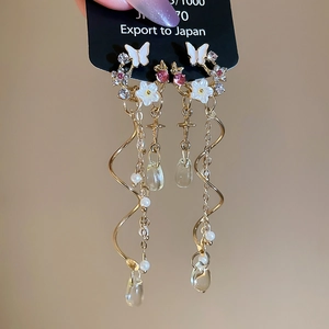 Detailed macro view of S925 silver needle drop earrings with pearl tassels and crystal charms