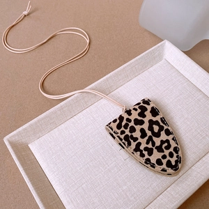 Detail of leopard print faux leather necklace pouch with visible edge stitching