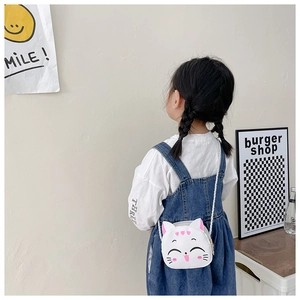 Rear view of a white cat-shaped kids shoulder bag worn by a model in casual style