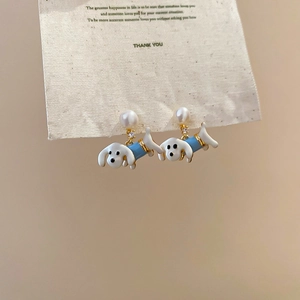 Detail of cute dachshund earrings with blue enamel, pearls and zircon on display card