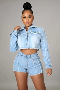 Close-up of light blue denim two-piece set with frayed edges and distressed details