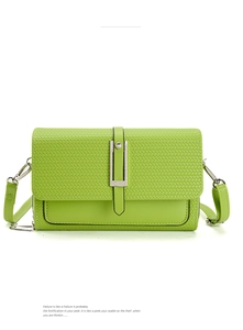 Detail of woven texture and silver metal clasp on a green crossbody shoulder bag