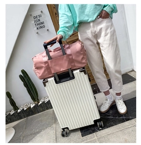 Pink nylon travel bag attached to a white suitcase handle for easy luggage carrying