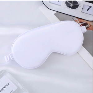 Detail of white silk sleep mask with smooth satin texture and elastic strap on silk fabric