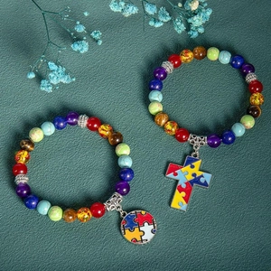 Detail of colorful stone yoga bracelets with puzzle heart and cross charms on dark leather
