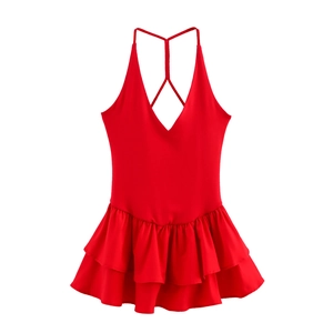 Detail of red halter dress with deep V-neckline and tiered ruffle hem on white background