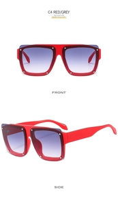 Detail view of red square frame sunglasses with grey gradient lenses and silver studs