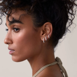 Three-piece silver hoop earring set with micro-pave zircons worn by a model