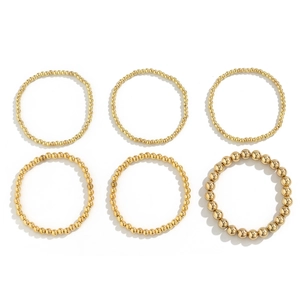 Macro shot of a 6-piece set of golden beaded bracelets with various bead sizes