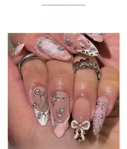 Detail of pink gradient Y2K stiletto press-on nails with 3D bows and star patterns