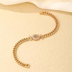 Macro detail of gold Cuban link bracelet with a light blue zircon centerpiece and pavé stones