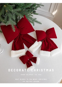 Detailed view of red velvet Christmas bows with white faux fur trim in three various sizes