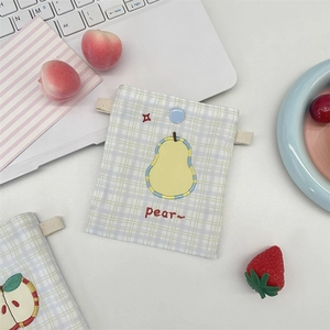 Detail of checkered fabric pouch with pear embroidery and blue snap button closure
