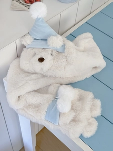Close-up of soft plush white bear hooded scarf with blue pointed hat and pom-poms