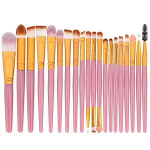 Macro shot of 20 professional makeup brushes with pink handles and golden metal tubes