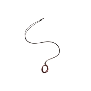 Collier avec pendentif géométrique irrégulier rouge foncé et cordon noir sur fond blanc