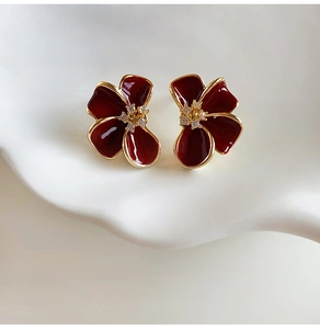 Macro de boucles d'oreilles fleurs rouges plaquées or 18 carats avec zircon sur plateau