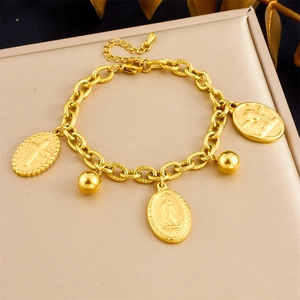 Detail of gold-plated stainless steel chain bracelet with religious coin charms on a tray