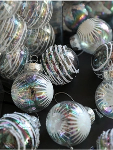 Macro view of iridescent Christmas ball with white glitter patterns and snowflake metal cap