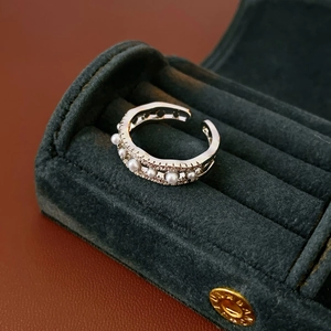 Detail of wave-shaped ring with white pearls and crystals in a velvet jewelry box