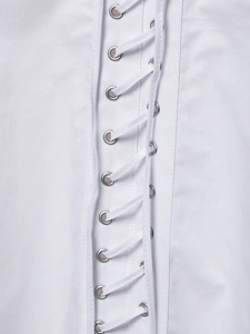 Detail of white blouse featuring metal eyelets and drawstring lace-up design
